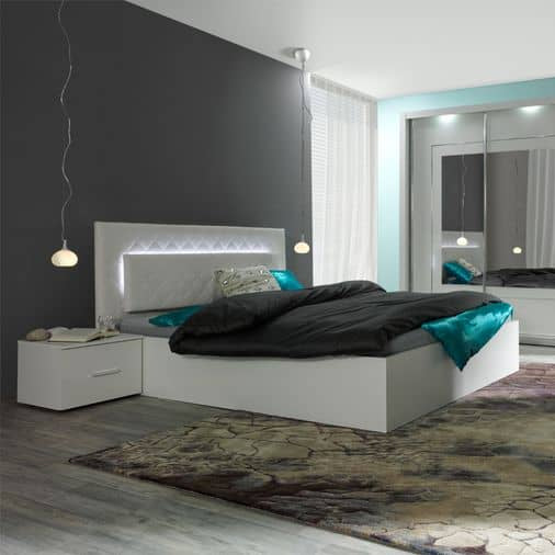 Modern bedroom with a white bed, nightstands, and decorative rug.