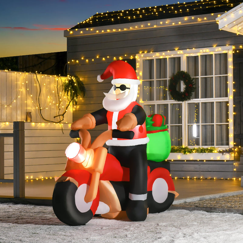 Inflatable Santa Claus on a motorcycle with a gift in front of a house decorated with Christmas lights.
