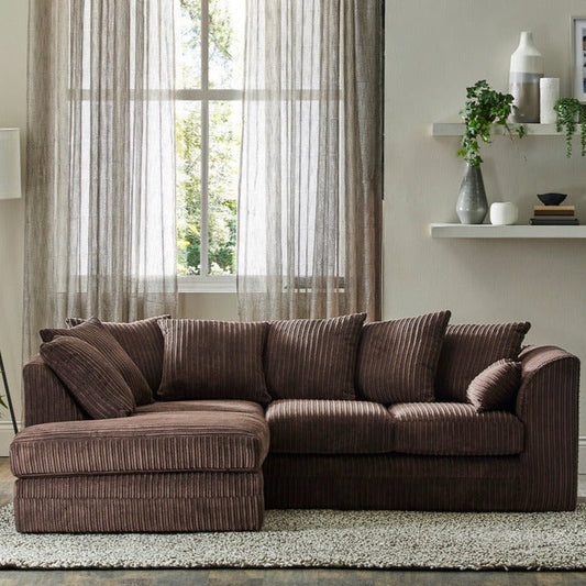 A brown corduroy fabric Chicago corner sofa with deep memory foam cushions, placed in a room with curtains and a window in the background.