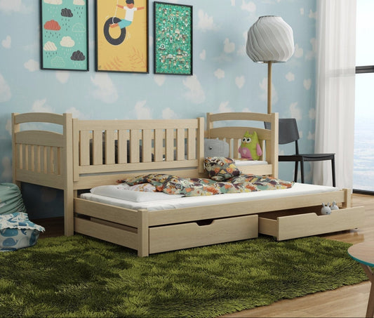 Wooden bed with pull-out drawer in a room with colorful wall art and a lamp.