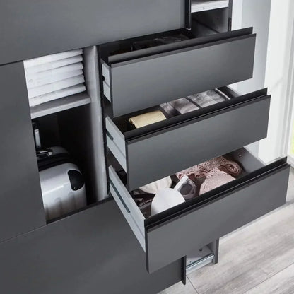 Gray dresser with open drawers containing various items in a well-lit room.