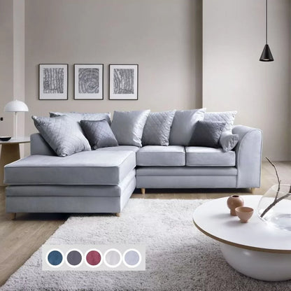 A silver blue velvet corner sofa with multiple cushions, placed in a room with a white rug and a coffee table, alongside a color palette indicating the available color options.