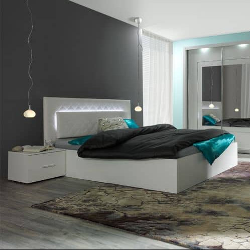 Modern bedroom with a white bed, nightstand, and decorative rug.