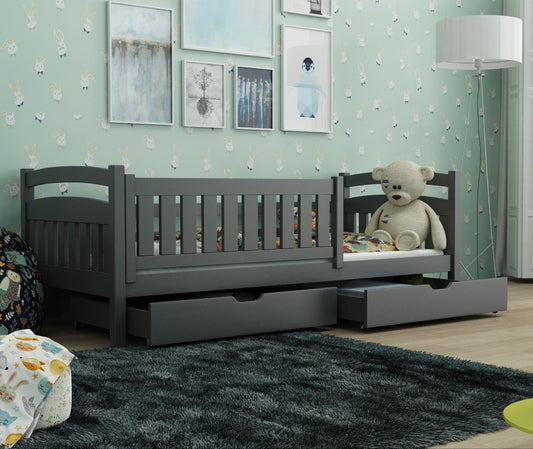Gray crib with drawers in a room with light green walls and decorative elements.